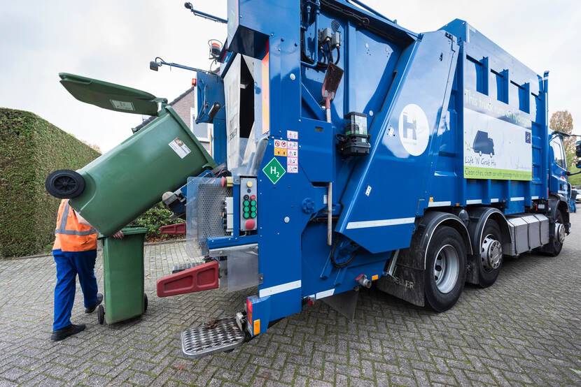 Vuilniswagen op waterstof leegt een vuilnisbak